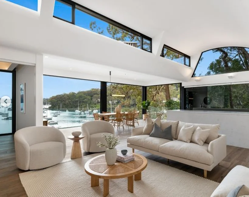 Newport home bright living area with water views, modern furniture, and high ceilings.